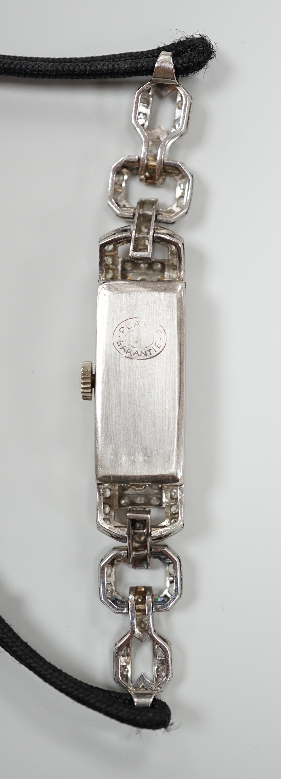 A lady's 1930's/2940's white metal (engraved All Platine) and diamond set manual wind cocktail watch, on a twin fabric strap.